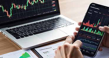 User analyzing charts on multiple monitors